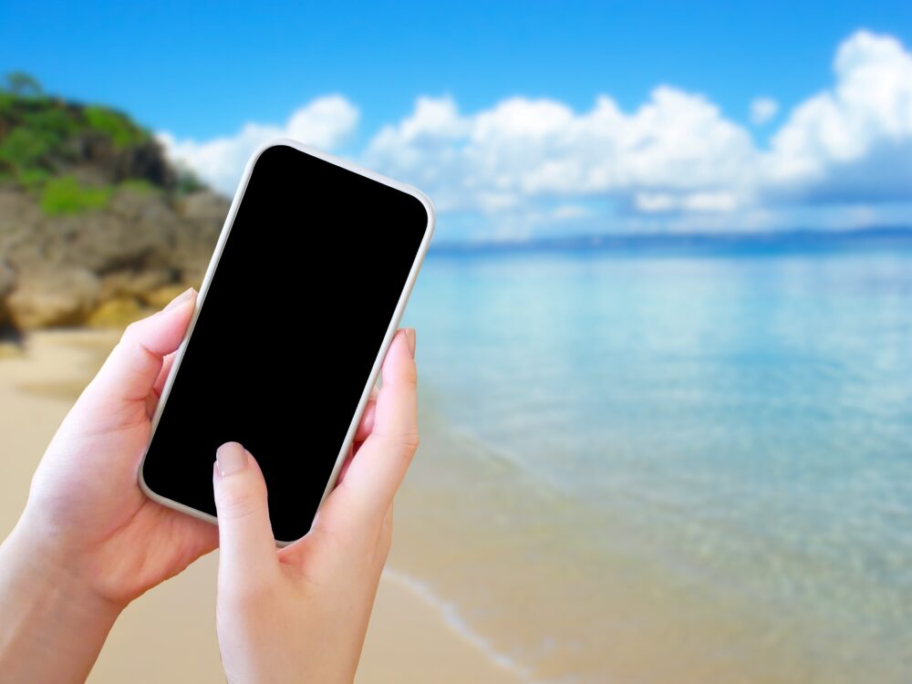 携帯電話を海で使用している人